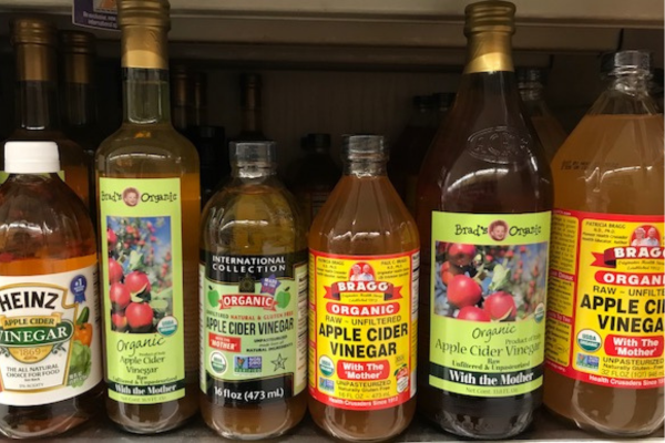 Different brands of apple cider vinegar on a grocery store shelf