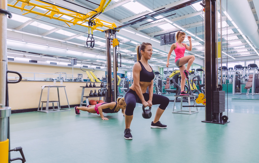 Group of beautiful women training hard in a crossfit circuit on fitness center