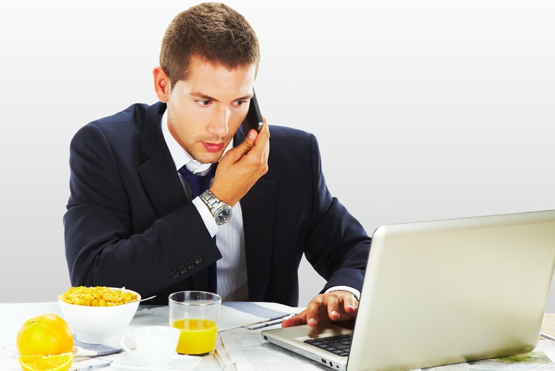 busy businessman using his laptop while having breakfast