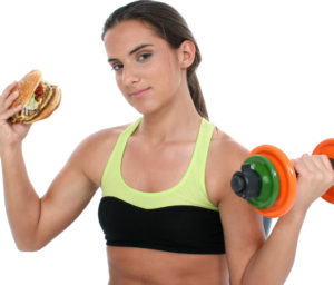 Beautiful Teen Girl Holding Colorful Weights And A Giant Cheeseb