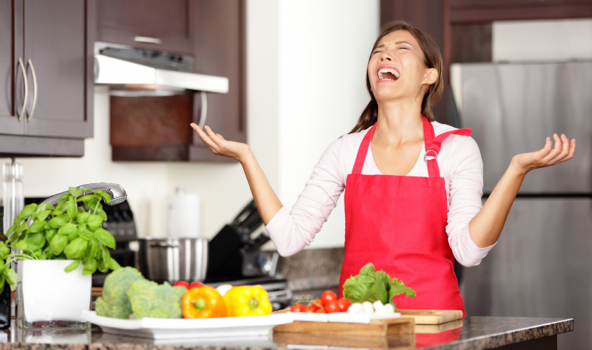 Funny cooking image of woman crying and screaming in kitchen giving up making food after unsuccessful cooking attempt. Beautiful young mixed-race Asian Chinese / Caucasian woman in kitchen.