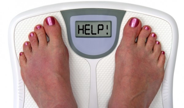 Feet on a bathroom scale with the word help! on the screen. Isolated.  Includes clipping path.