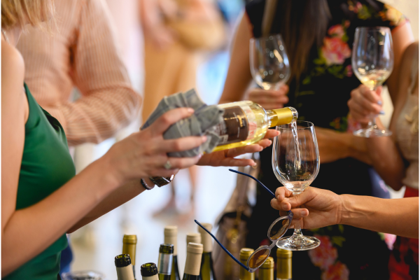 People socializing and pouring wine at a gathering