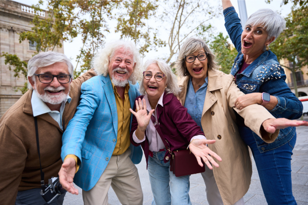 Group of joyful older adults smiling and laughing together outdoors, representing social connection and healthy aging