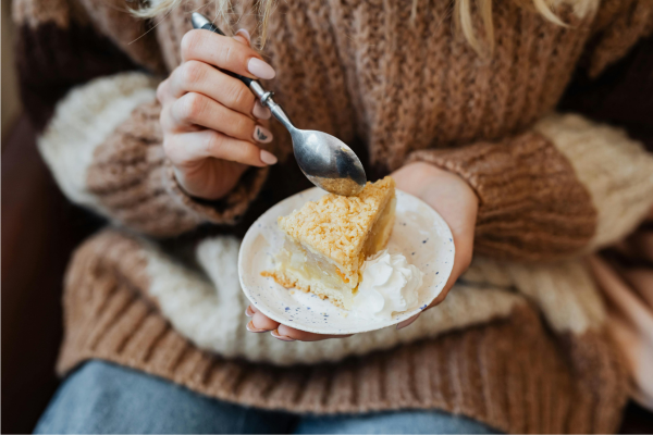 Woman holding a plate with pie at Thanksgiving, representing how to handle unwanted comments about eating during holiday meals.