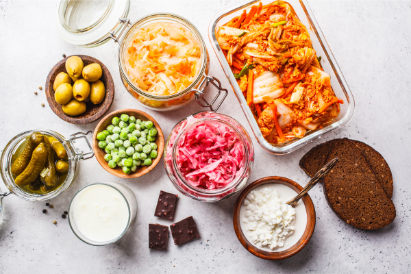 Assorted fermented foods like kimchi, sauerkraut, pickles, and yogurt that support gut health