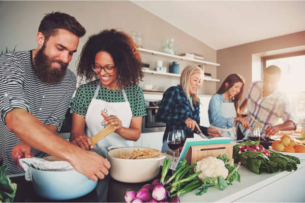 Diverse group preparing a balanced meal with fresh produce in a kitchen