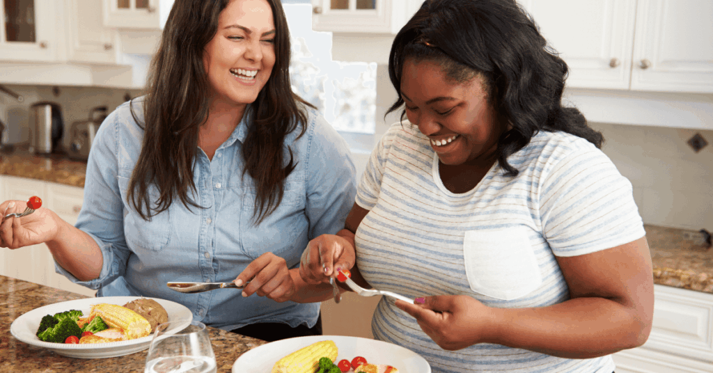 Two women enjoying a balanced meal, supporting healthy GLP-1 hormone function and sustainable weight loss.