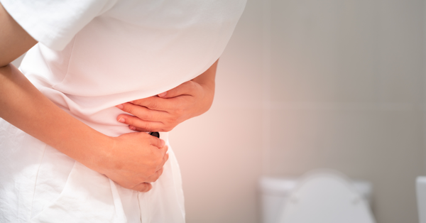 Person holding their abdomen due to abdominal discomfort from constipation
