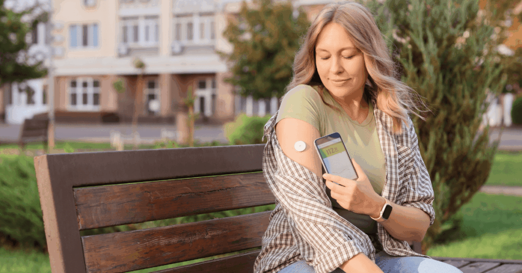 Woman wearing a continuous glucose monitor on her arm while checking blood sugar levels on her phone without diabetes