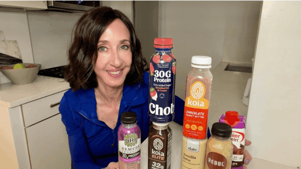 Dietitian holding ready to drink protein shakes including plant based and dairy options for easy high protein intake